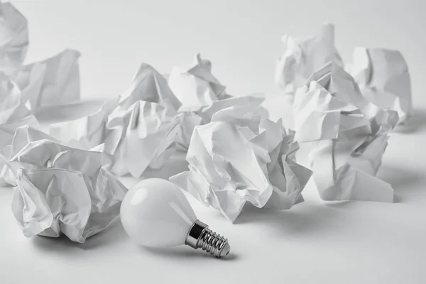 Close Shot Energy Saving Light Bulb Crumpled Papers White — стоковое фото