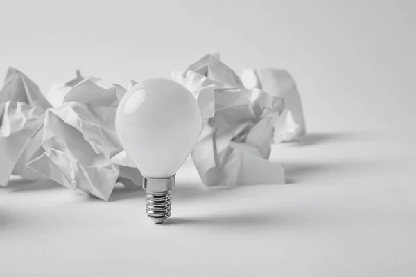 Close Shot Power Saving Light Bulb Crumpled Papers White — стоковое фото