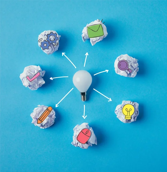 Top View Light Bulb Surrounded Crumpled Papers Business Icons Blue — стоковое фото